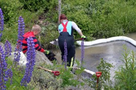 Saara Suolahti ja Mikko Rantala lapioivat turpeeseen imeytettyä polttoöljyä Kroopinojasta Mikolantien sillan alta.