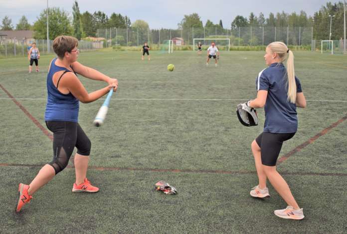 Annika Nurmi lataa mailaan voimaa ja töräyttää lyönnin keskikentälle. Veera Toikka seuraa, kuinka onnistuneeseen syöttöön tulee onnistunut lyönti. (Kuva: Tuomas Honkasalo)