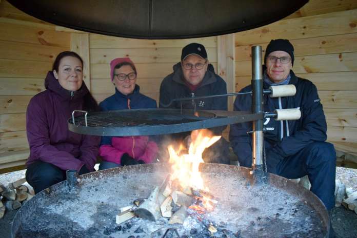 Marja Ekman, Päivi ja Teuvo Pohjola sekä Markus Salo testailivat Kyrön uutta kotalaavua ja pitivät suojaa kovalta tuulelta ja sateelta viime perjantaina. (Kuva: Tuomas Honkasalo)