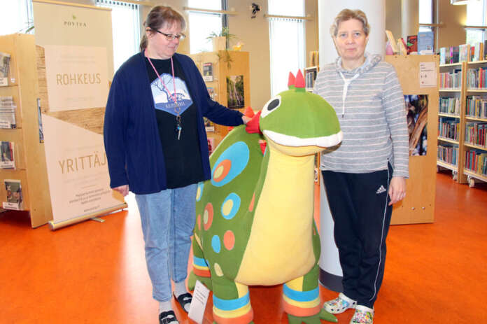 Leena Viljanen ja Terhi Laine lohikäärmeen äärellä Kyrön kirjastossa. Lohikäärmeestä ei tule lainattavaa, vaikka pöytyäläiset päättäisivätkin ohjata osallistavan budjetoinnin rahat kirjastolle. Monesta muusta hyödykkeestä sen sijaan voi tulla. (Kuva: Asko Virtanen)
