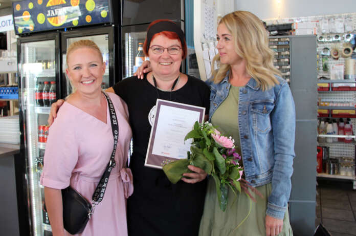 Maiju Joutsimies ja Tanja Halminen Auranmaan Nuorkauppakamarista yllättivät positiivisesti Auranmaan positiivisimmaksi valitun Aila Lepistön, kun kävivät perjantaina ojentamassa palkinnon Lepistölle. (Kuva: Asko Virtanen)