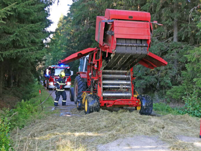 Palomiehet varmistivat, etteivät liekit päässeet leviämään paalauskoneesta maastoon. Kuva: Simo Päivärinta.