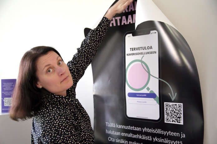 Auran kunta on vuoden verran testannut Kaverisovellusta, jota nyt on tarkoitus ruveta markkinoimaan kuntalaisille näkyvämmin. Auran hyvinvointijohtaja Jaana Ranta-aho sovittelee seinälle Kaverisovelluksen julistetta.