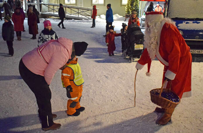 Topias Hongisto, 4, suojautui joulupukilta turvallisen matkan ja turvallisen isoäidin, Eija Hongiston, suojiin. Pukille saatiin kuitenkin huikattua lahjatoive eli leluimuri. (Kuva: Tuomas Honkasalo)
