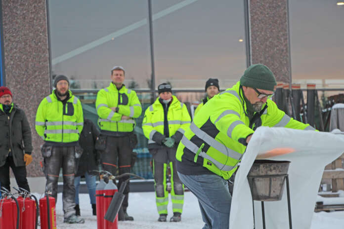 Sami Timonen tukahduttaa paloa sammutuspeitteellä Kosken Alumiinivalmisteen väelle järjestetyssä alkusammutuskoulutuksessa.