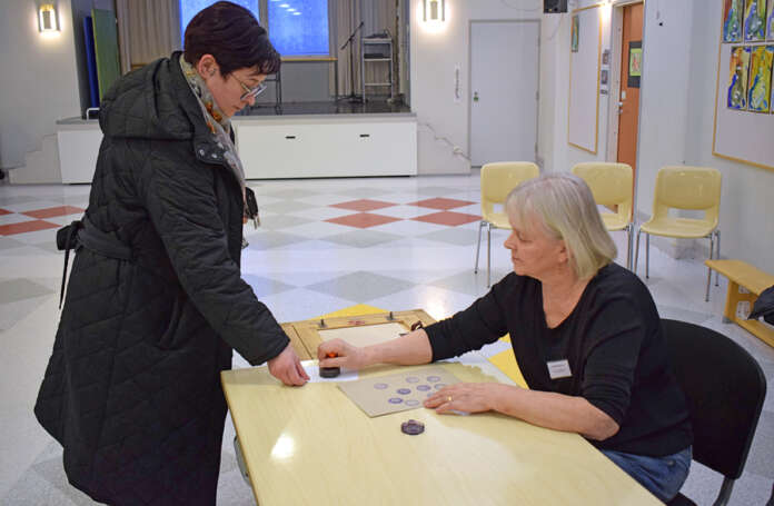 Outi Lintuaho kertoi ennen vaalihuoneistoon menoa, ettei ole täysin varma vielä, ketä aikoo äänestää. Äänestyskopissa valinta kuitenkin tuli tehtyä. Lintuaho sujautti leimatun äänen muiden joukkoon Arja Tuomisen toimiessa vaalivirkailijana. Kuva: Tuomas Honkasalo