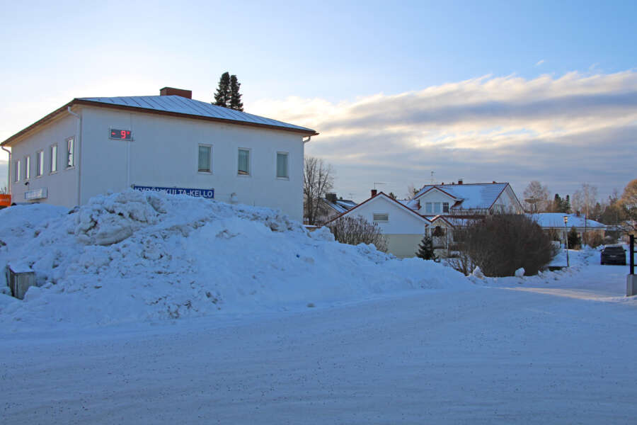 Tässä talvisessa maisemassa värimaailma on valkoinen ja kylmänsävyinen. Lämpömittari näyttää pakkasta.