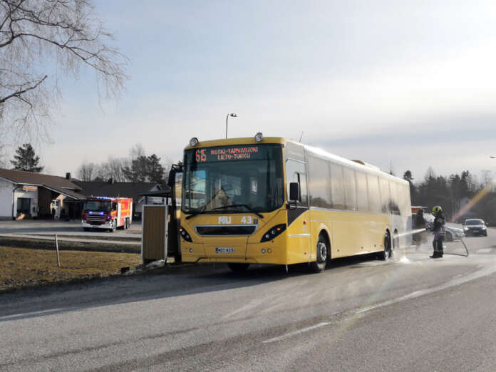 Palokunta jäähdytteli linja-auton tuleen syttynyttä rengasta Marttilassa maanantaiaamulla. Kuva: Simo Päivärinta.