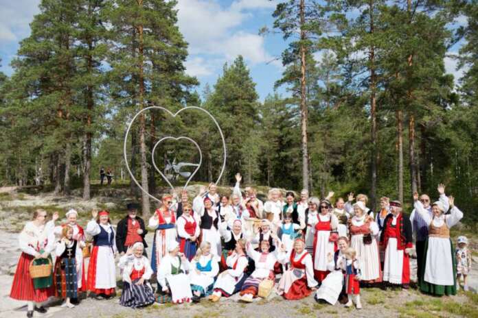 e58bcebc-465c-4f51-954f-1523f80f5d8d Vuonna 2023 Kansallispukutuuletuksessa nähtiin useita kansallispukuja ja yleisöäkin oli noin 300 henkeä. Kuva: Tuija Sauran kotialbumi.