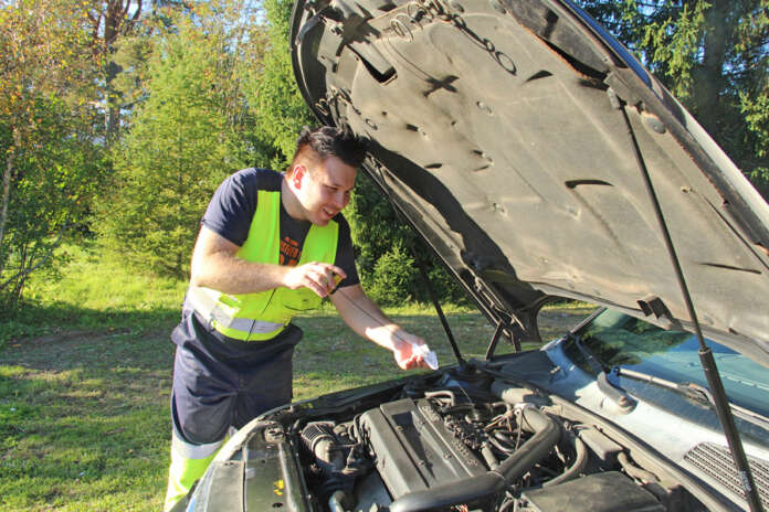 Konepellin alle kurkistanut Riku Huida tarkisti moottoriöljyn tason olevan vakaasti mittatikun ylämerkissä. Kuva: Jorma Kaarto