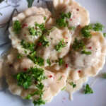 Ruokaisat suolaiset pierogit on koristeltu persiljasilpulla.
