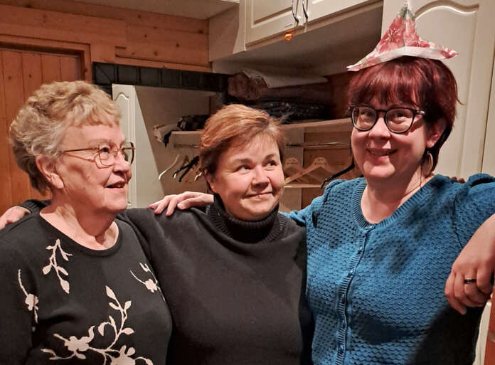 Paula Ahola (oik.) sai toiminnanjohtajan pestinsä kunniaksi edeltäjiltään Taina Salolta ja Heli Virtaselta kuvaushetkellä käsillä olevista materiaaleista loihditun juhlahatun. Teatterin parissa jo pitkään toiminut kolmikko jaksaa hymyillä, sillä he luottavat siihen, että kaikella on tapana järjestyä. Kuva: Emmi Lovén