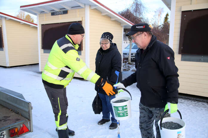 Vuoden klubiksi valittu Kosken Lions Club on monessa mukana. Klubi jakoi hiekoitussepeliä viime joulukuussa. Martti Erelä (vas.) ojentaa hiekotussepeliä Esko Sorvarille. Päivi Sorvari tarkkailee toimitusta sivusta. Kuva: AVL:n arkisto / Susanne Hiltunen