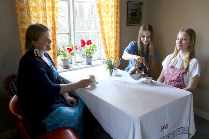 Aino Nurmi, Saimi Nurmi ja Hilda Havuaho toivottavat kahvittelijat tervetulleeksi perinteikkääseen Tuomolan tupaan.