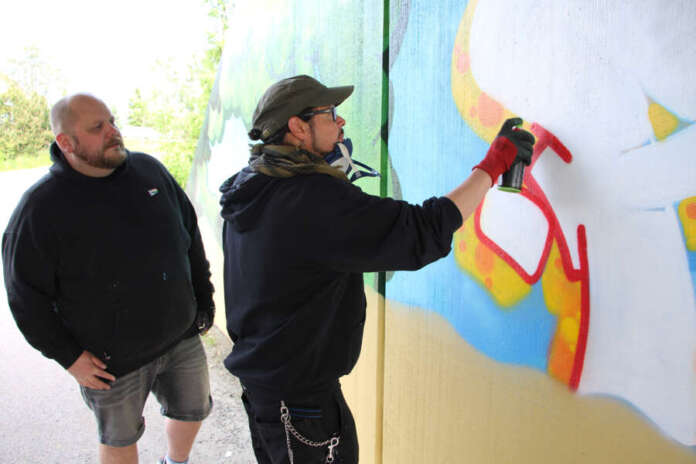 Lauri Kouki seurasi, kun Salim Sheikh viimeisteli Auran Aurikoviikko-graffitiin a-kirjainta.