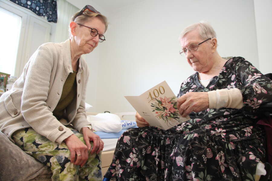 Aune Hongisto lukee äitinsä Maire Kivisen kanssa 100-vuotispäivän alla saapuneita onnittelukortteja.